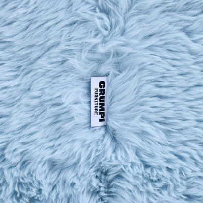 Close-up of the blue faux fur on the Beari Kids Armchair, with the Grumpi Furniture label 