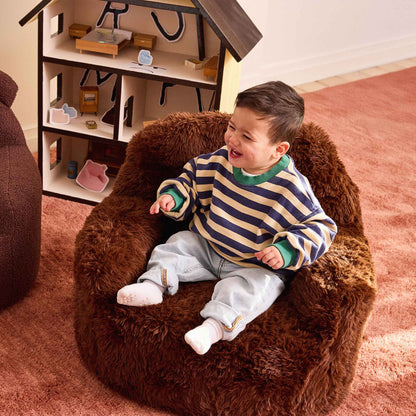 Laughing toddler in a striped jumper sitting in the brown Beari Kids Armchair 