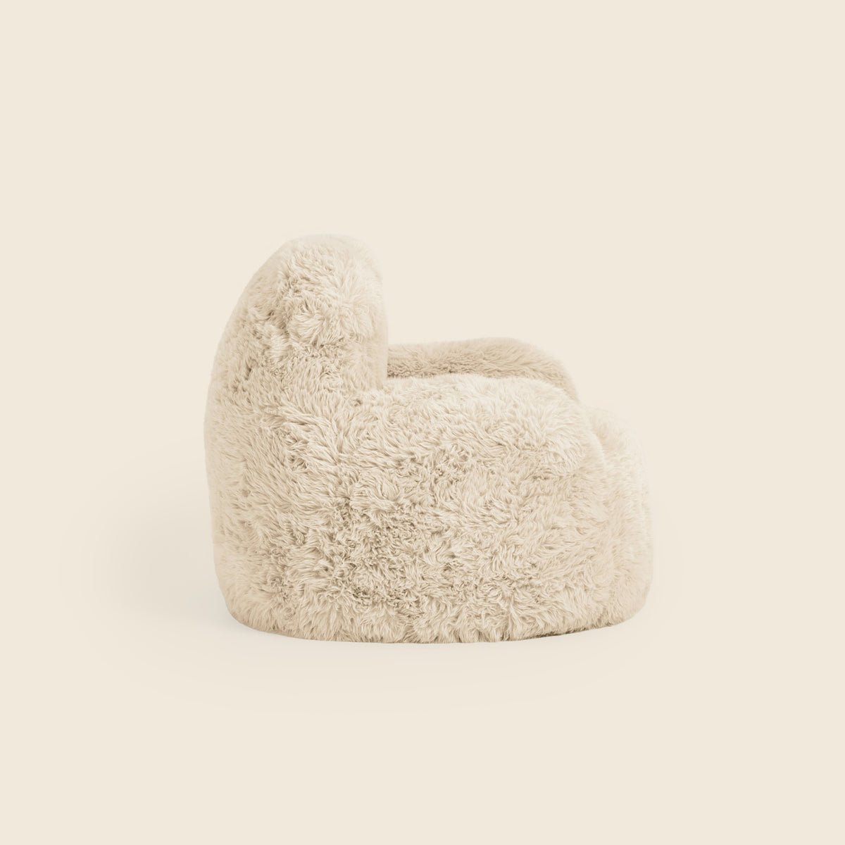 Side view of the cream Beari Kids Armchair on a beige background 