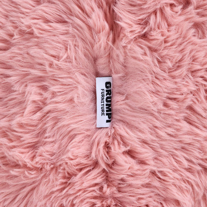 Close-up of the pink faux fur on the Beari Kids Armchair, with the Grumpi Furniture label 