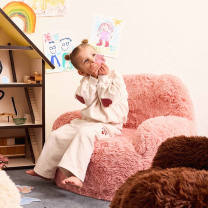 Girl sitting in the pink Beari Kids Armchair in a playroom 