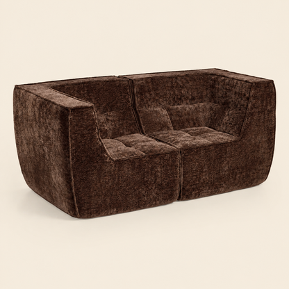 A modern two-seater sofa upholstered in dark brown textured velvet, shown from a three-quarters angle against a solid light beige background. 
