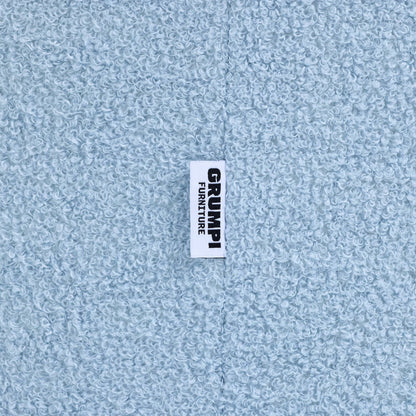 Close-up of the blue teddy fabric on the Teddi Kids Armchair, with the Grumpi Furniture label 