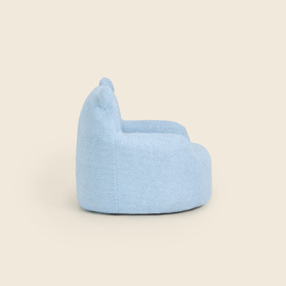 Side view of the blue Teddi Kids Armchair on a beige background 