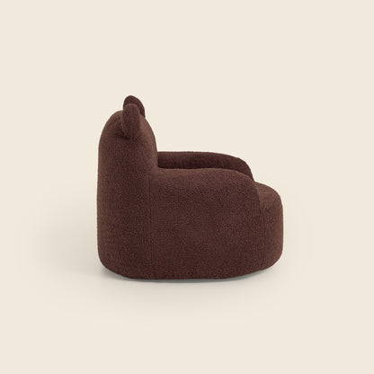 Side view of the brown Teddi Kids Armchair on a beige background 