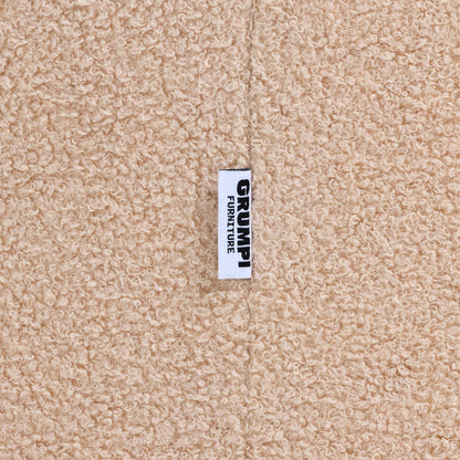 Close-up of the cream teddy fabric on the Teddi Kids Armchair, with the Grumpi Furniture label 