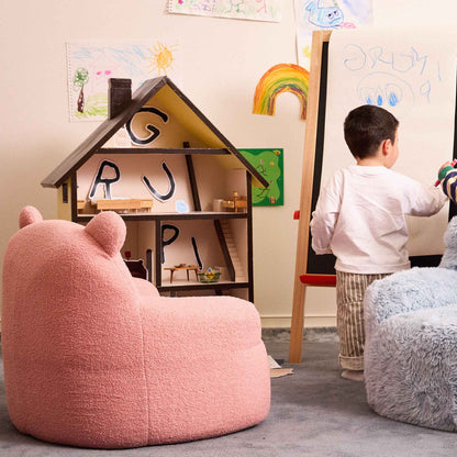 Pink Teddi Kids Armchair beside a dollhouse while a boy draws at an easel 