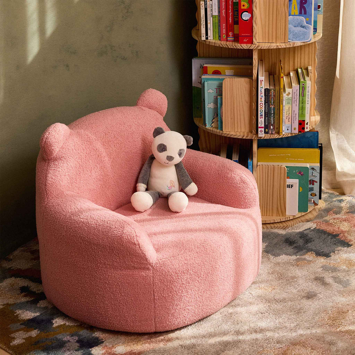 Pink Teddi Kids Armchair with a plush panda on the seat 